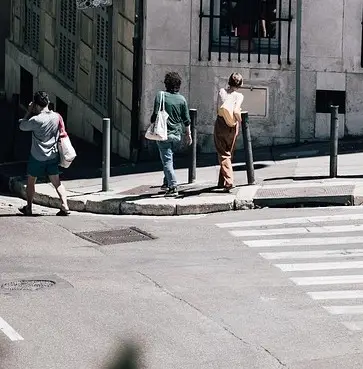 Street corner with no dropped kerb and metal posts blocking access to the crossing