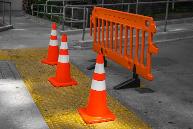 Roadworks cones and barriers obstructing tactile paving, blocking safe pedestrian access